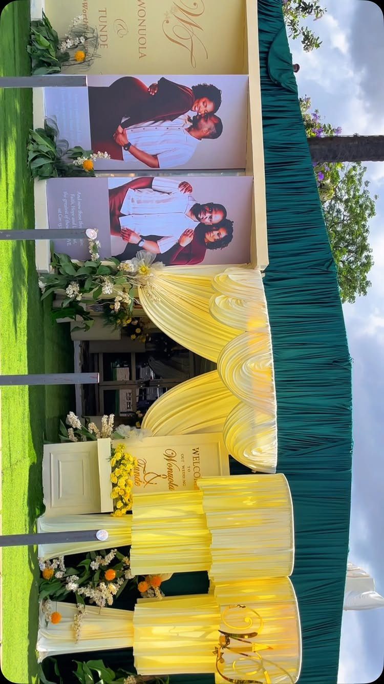 Emerald green draped backdrop with gold chair covers and wedding welcome signage.