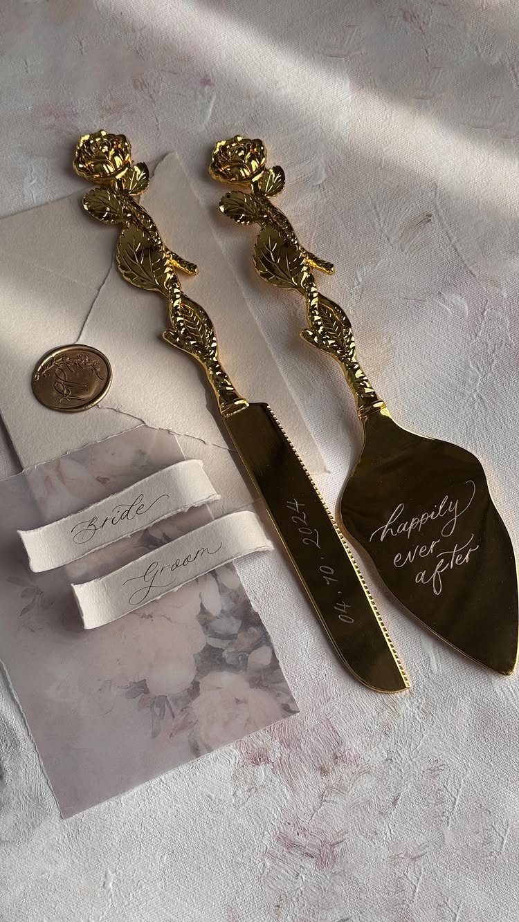 Gold cake knife and server set with rose handles and romantic engravings.