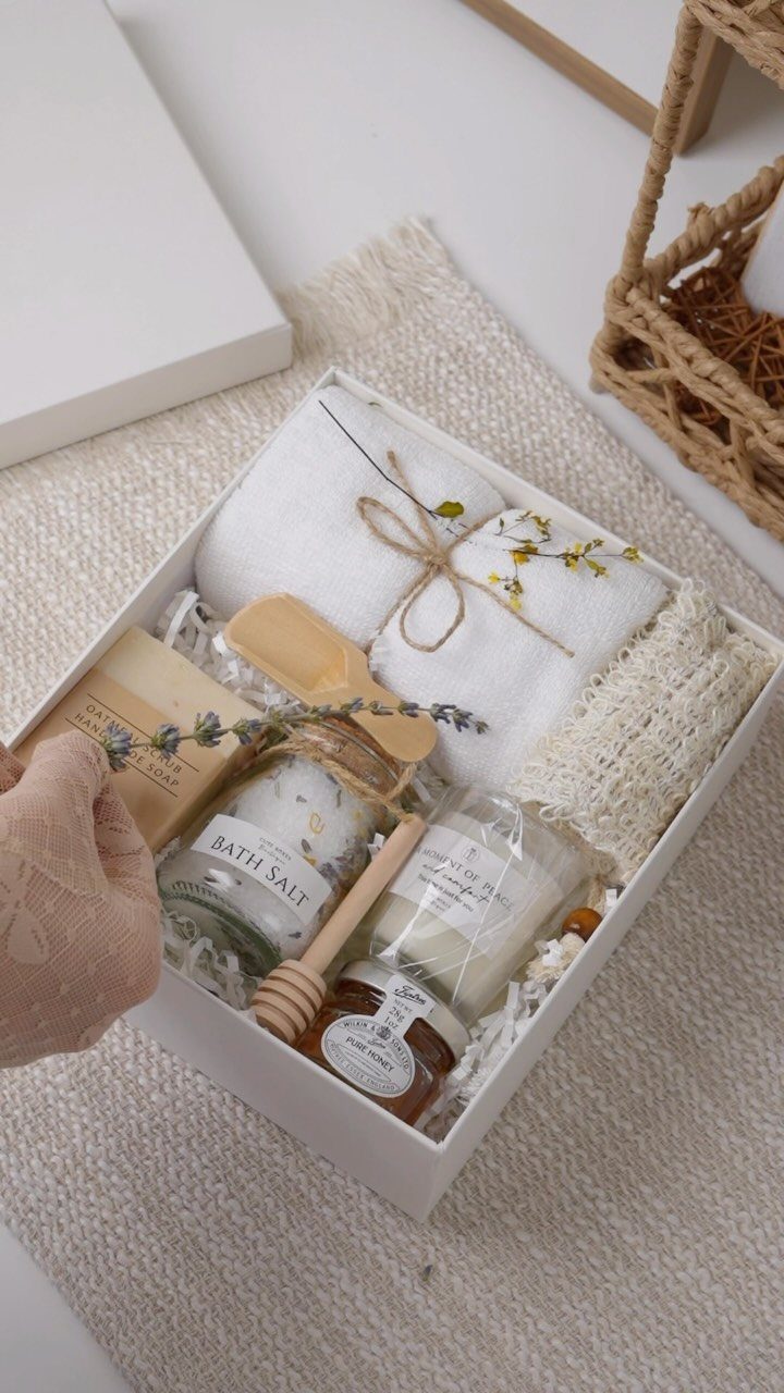 Spa gift box with white towel, bath salts, candle, honey, and soap.