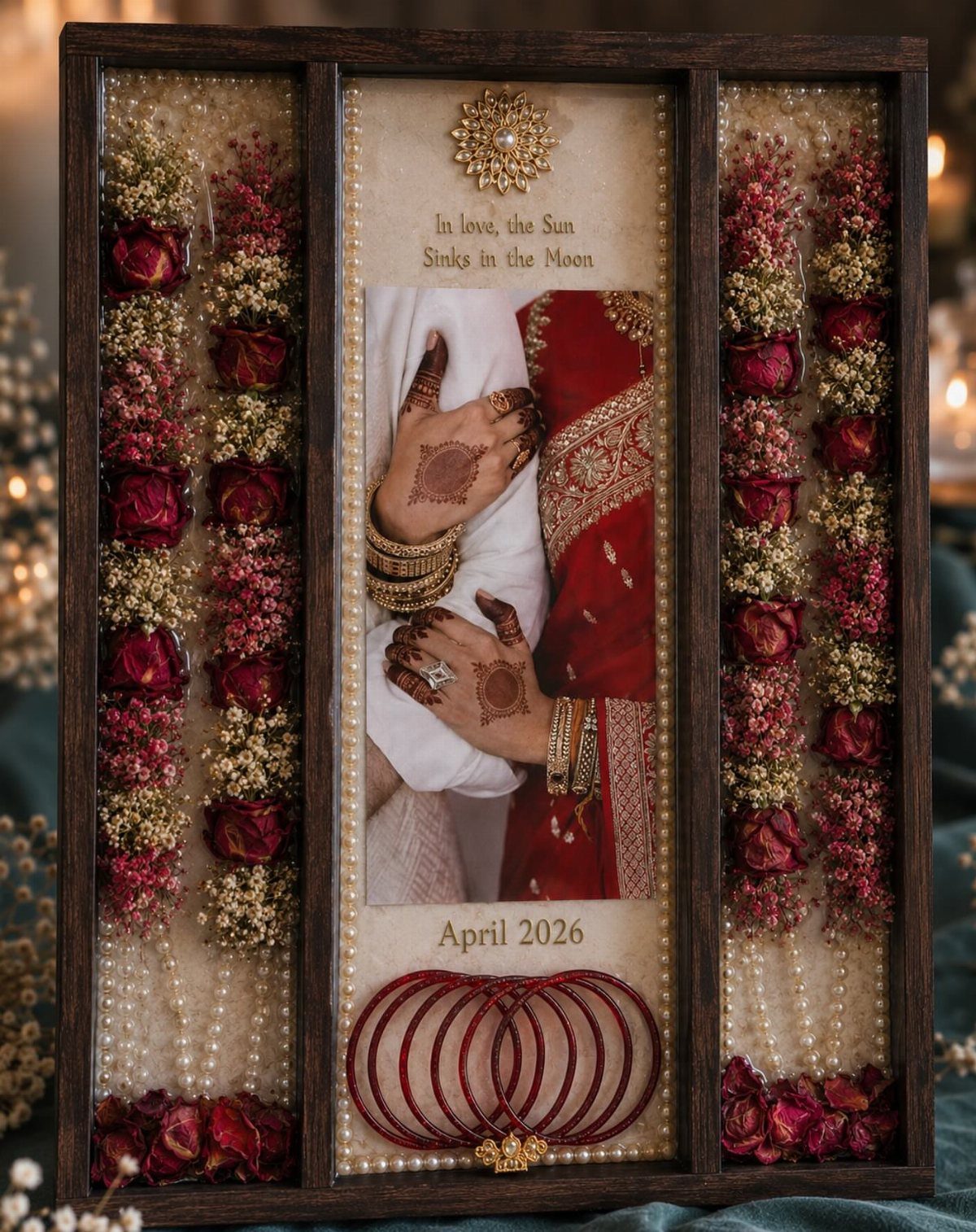 Wooden shadow box with wedding photo, dried red roses, pearls, and red bangles.