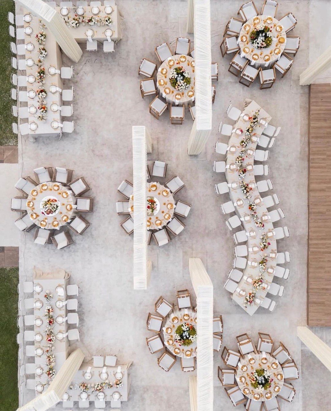Aerial view of wedding reception tables with white linens and matching white chairs.