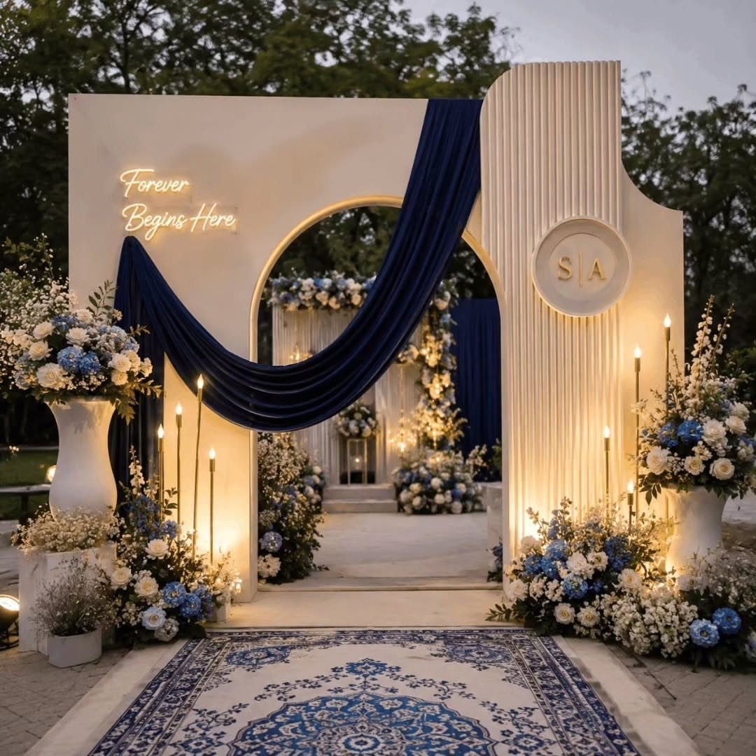 Navy blue fabric draped over a white wedding backdrop with blue floral arrangements.
