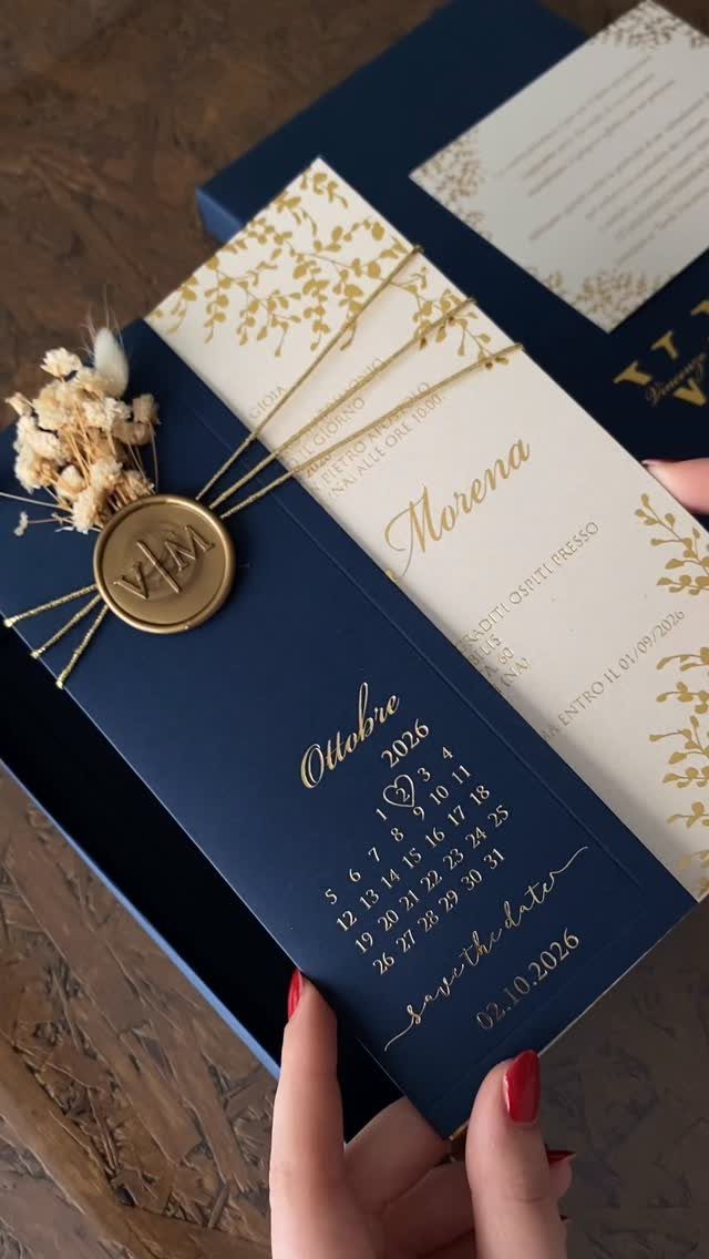 Navy blue and cream wedding invitations with gold foil and a wax seal.