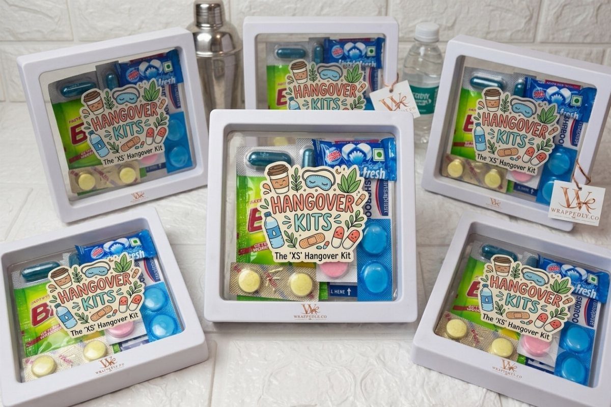 Six white hangover kit boxes with pills and packets on a white surface.