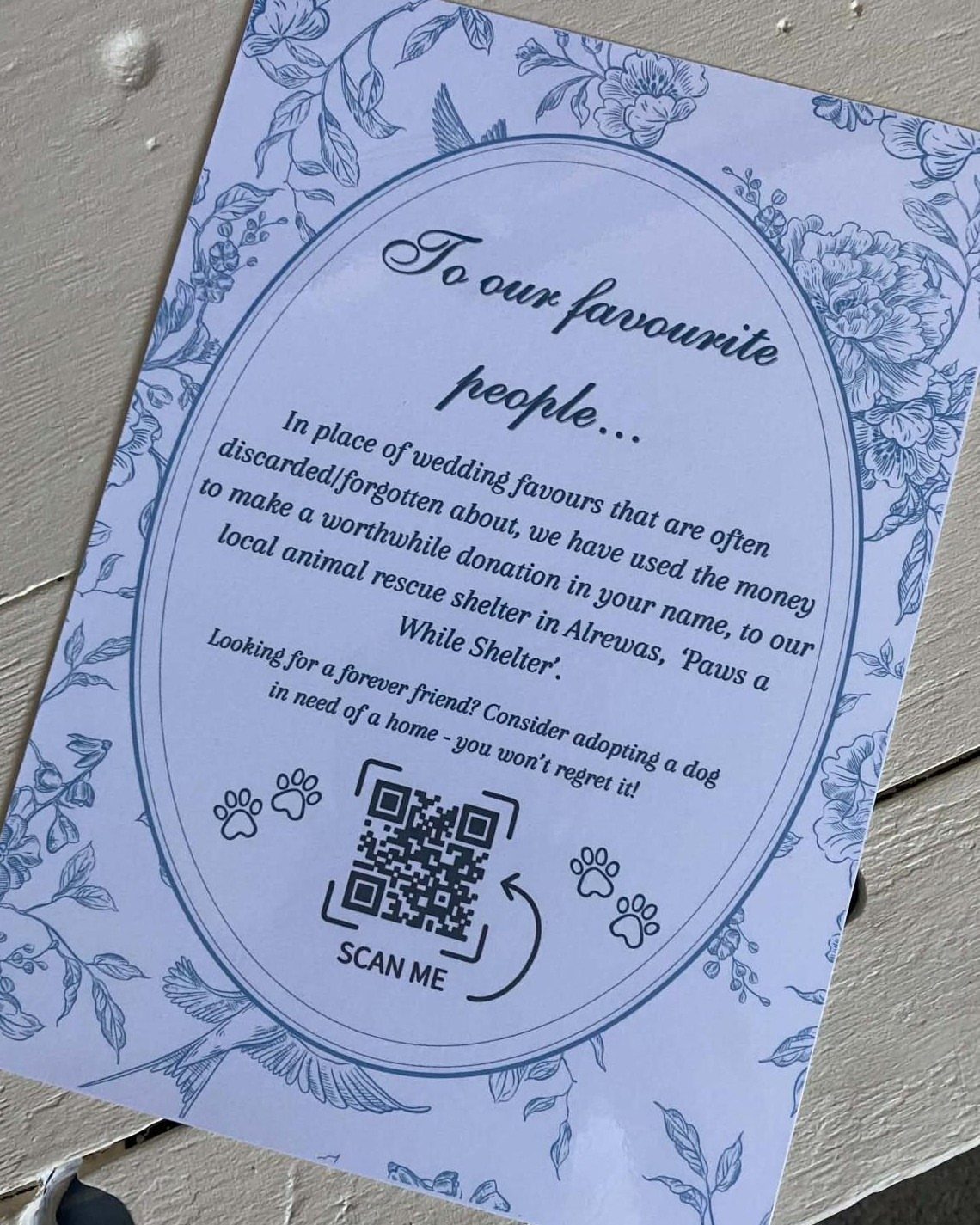Blue floral wedding card announcing a charity donation to an animal rescue shelter.