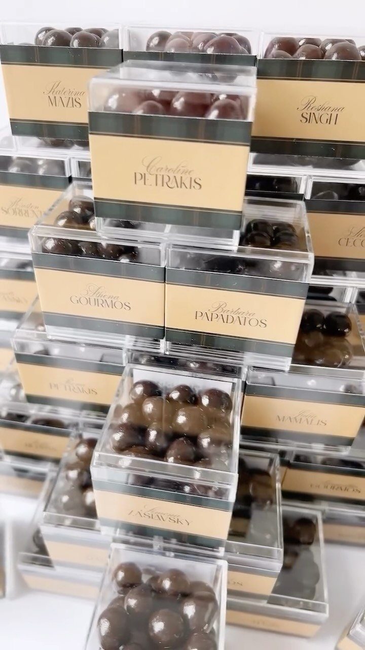 Chocolate-covered espresso beans in clear boxes with personalized gold name bands.