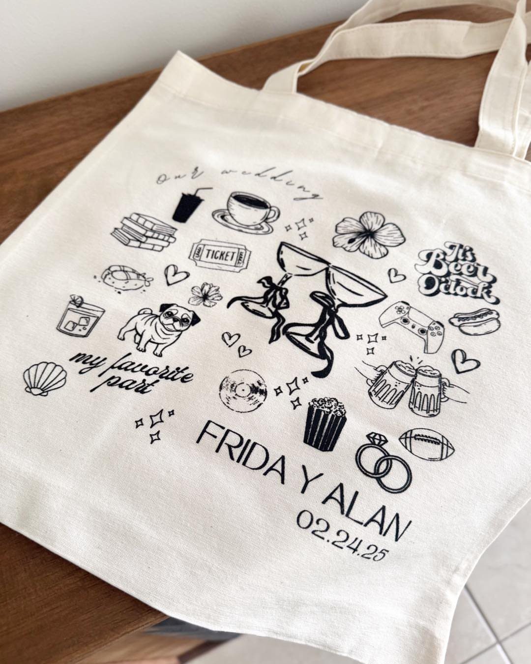 Canvas tote bag with personalized black line art and wedding names and date.