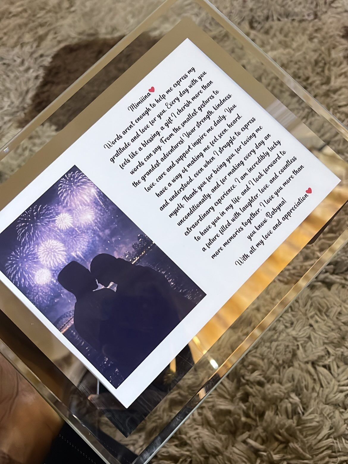 Handwritten love letter and couple's photo preserved inside a clear acrylic block frame.