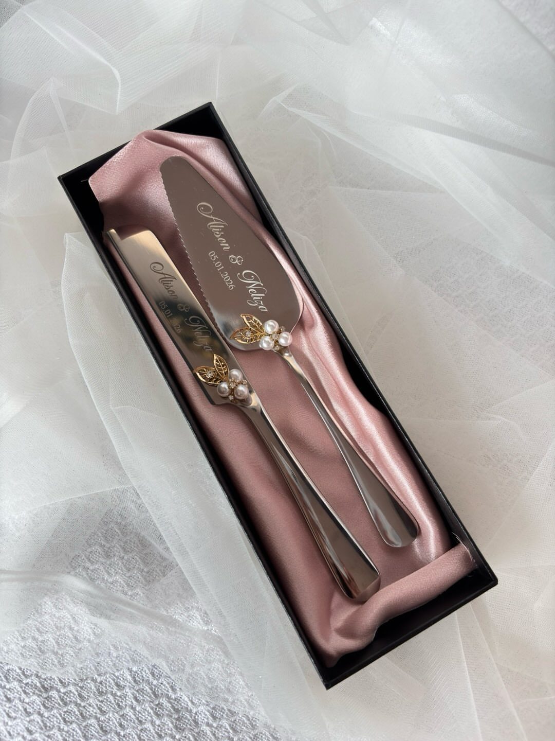 Engraved silver cake server and knife set in a pink satin lined box.