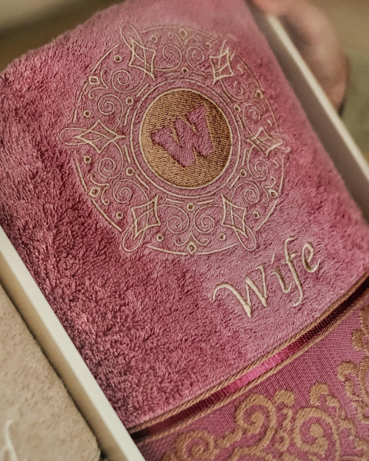 Mauve plush towel with white embroidered mandala and the word Wife in script