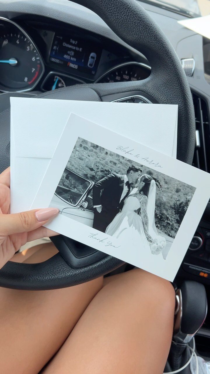 Thank you card featuring a black and white wedding photo held in a car.