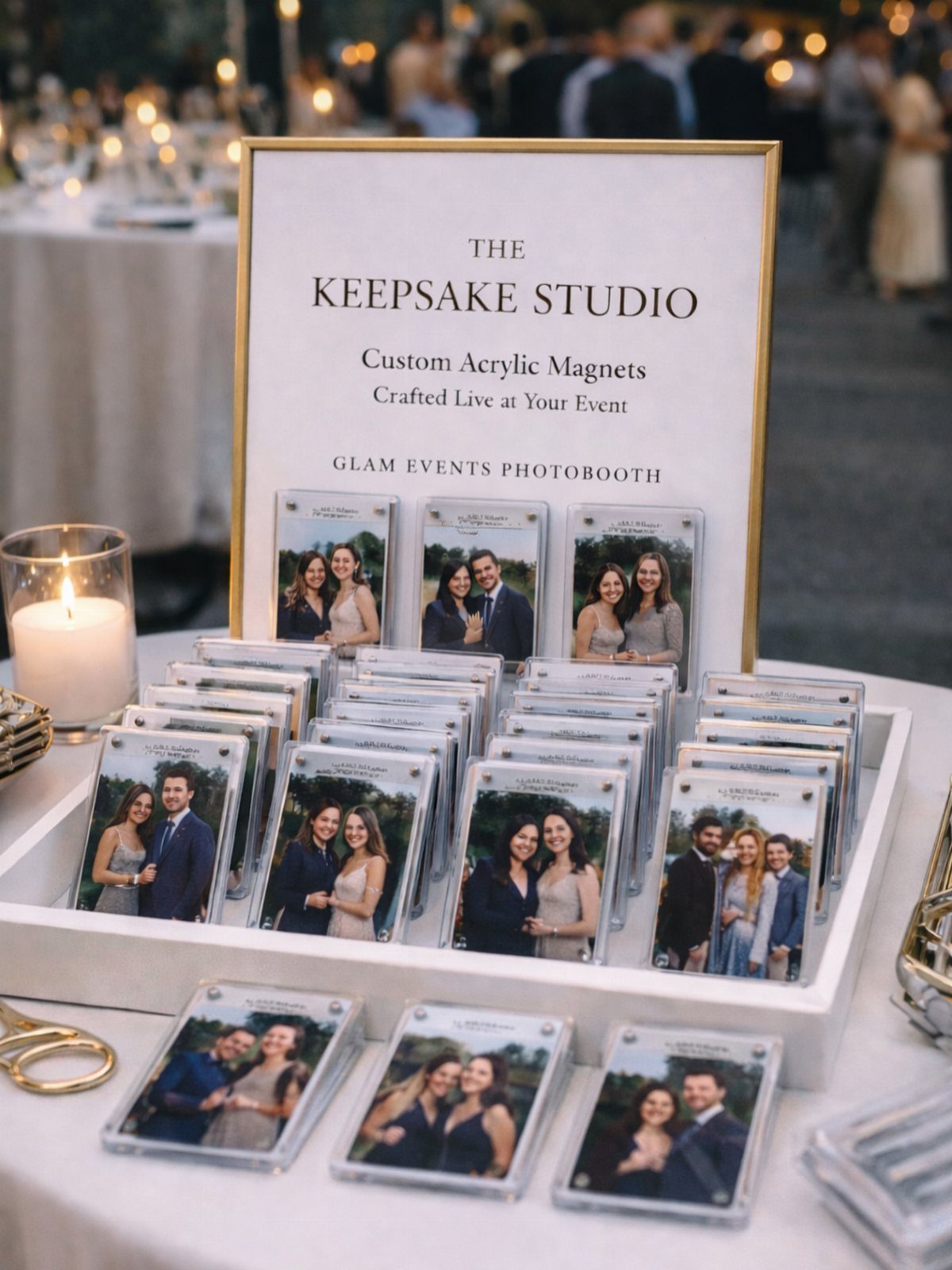 Acrylic photo magnets on a white tray next to a Keepsake Studio sign.