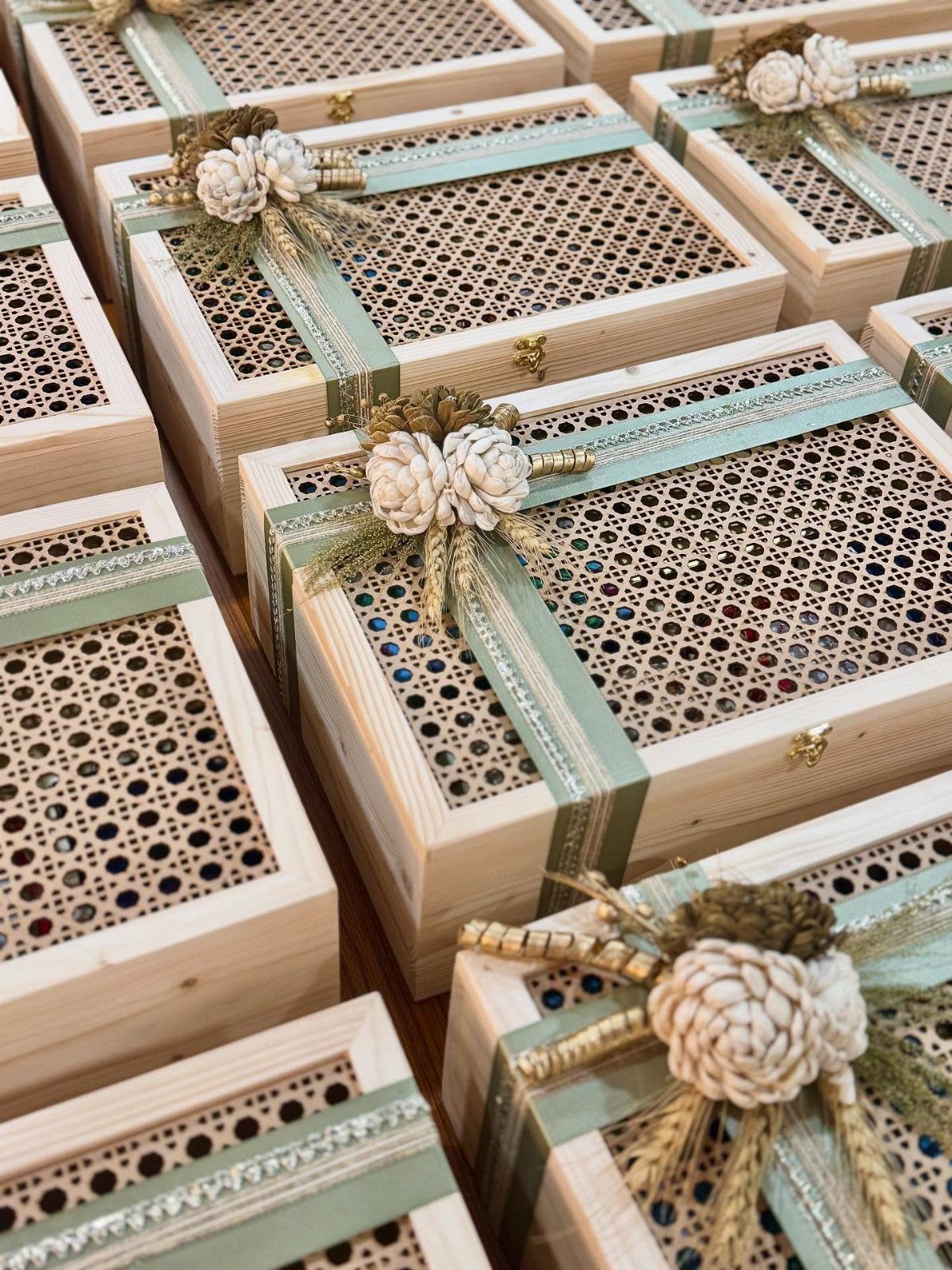 Small wooden keepsake boxes with lattice lids, green ribbons, and floral decorations.
