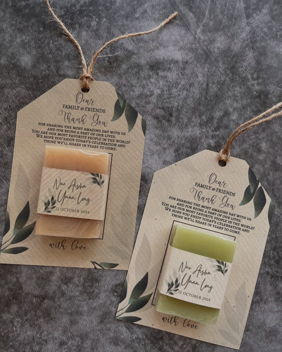 Handmade tan and green soaps attached to brown kraft paper wedding thank-you tags.