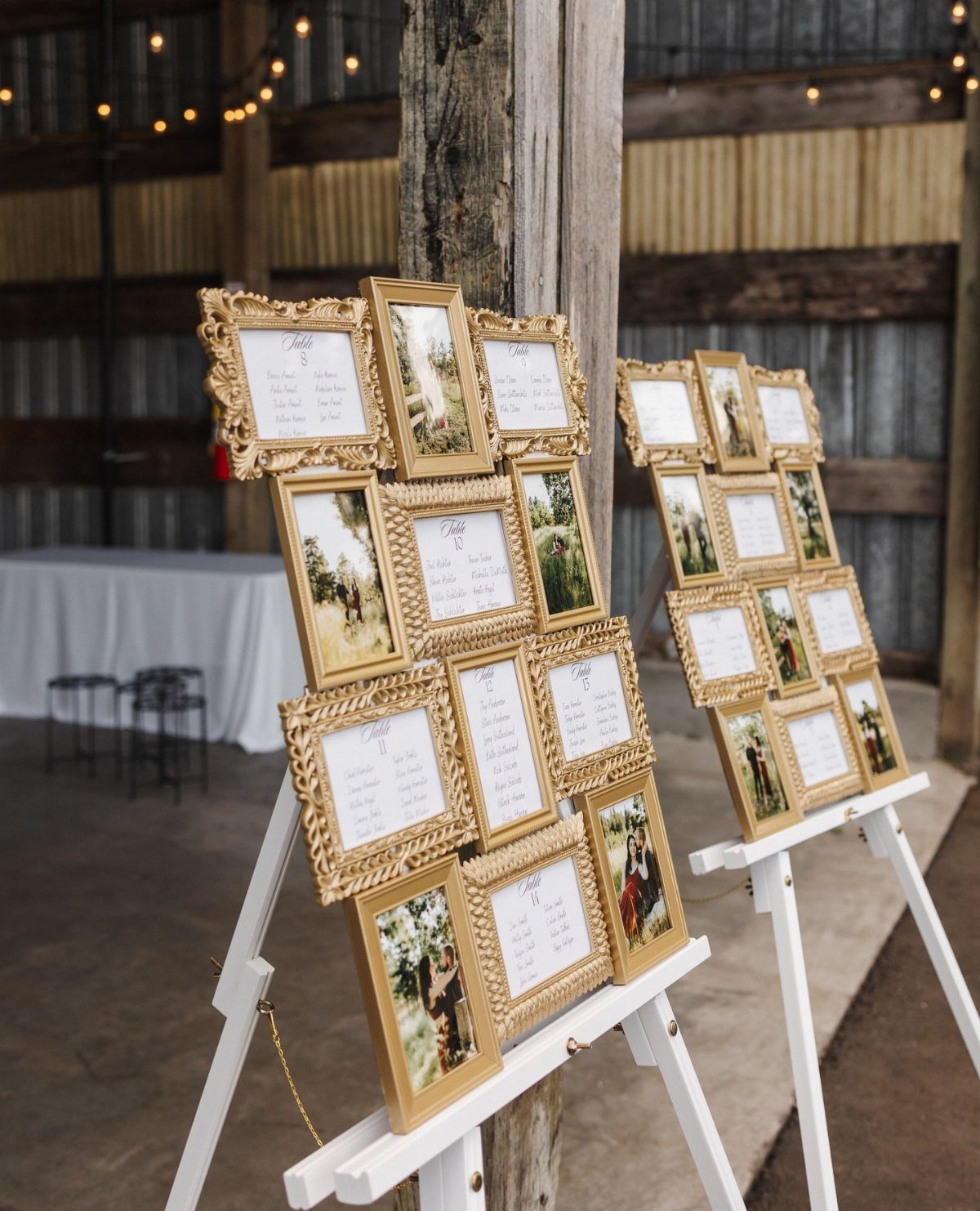 Gold picture frames arranged on a white easel displaying wedding seating assignments.
