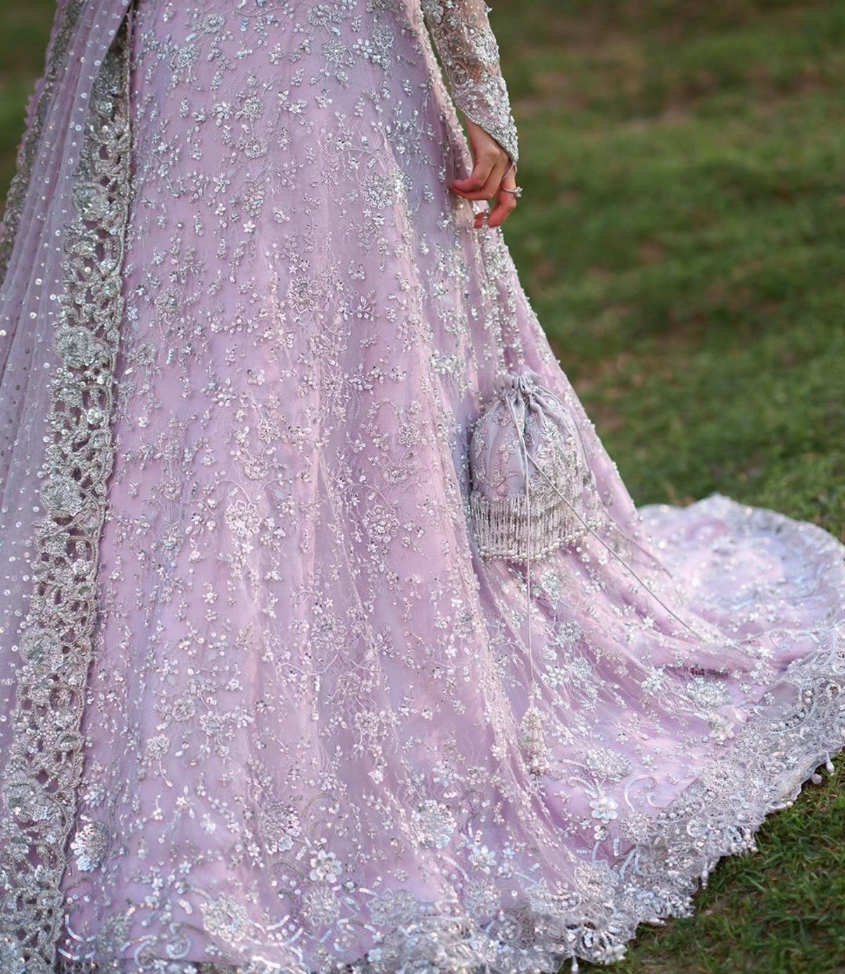 Lavender and silver embroidered gown with intricate sequins on a green grass background