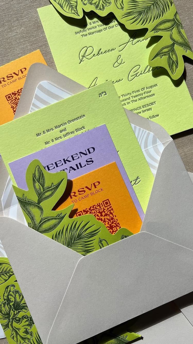 Wedding invitations in lime green and yellow with leaf cutouts in a grey envelope.